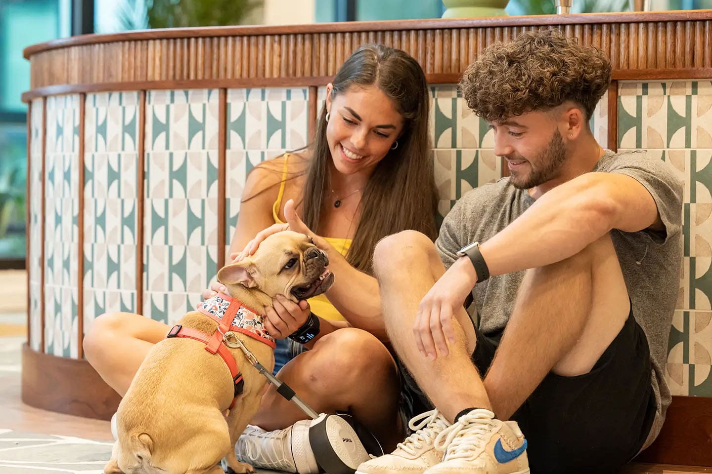 Two young adults with a cute dog.