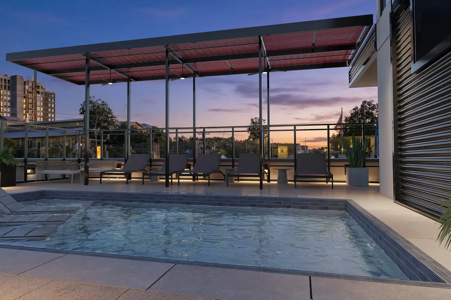 Pool with chairs surrounding it during sunset.